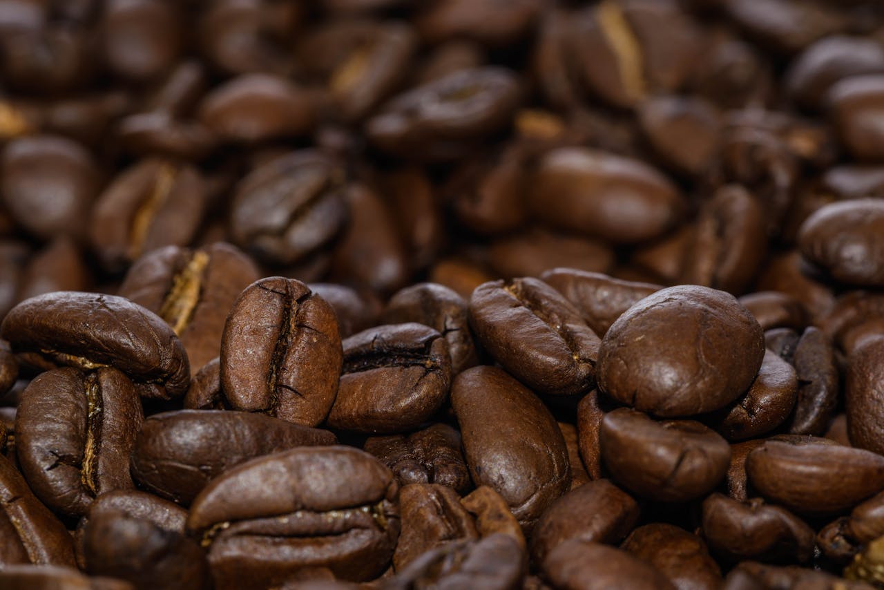 Close-up macro shot showcasing the rich texture of roasted coffee beans.